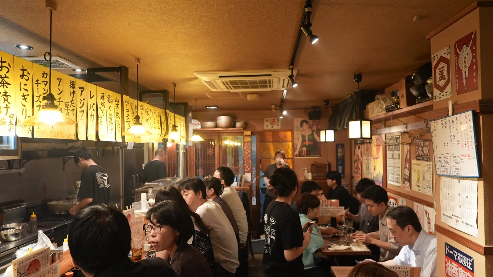 黄色い短冊とあたたかな照明の下でにぎわう金木犀の店内